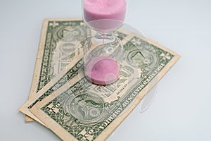 One dollar bills have hourglasses on them. The hourglass is located near the dollar bills