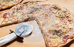 One domestic pizza with circle cutter knife on the wooden table selective focus, food background