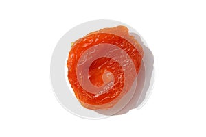 One dried apricot lies on a white background.