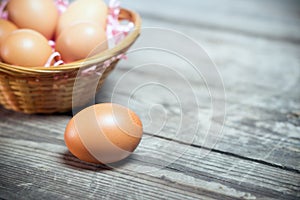 One egg on background basket with eggs in a rustic style