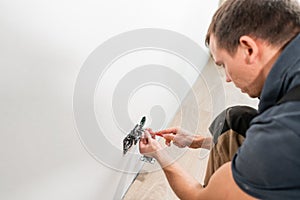 One electrician worker at wiring cable and light switch or power wall outlet socket installation work