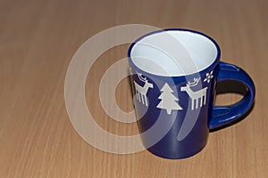 One empty blue mug with a handle with deer, Christmas trees