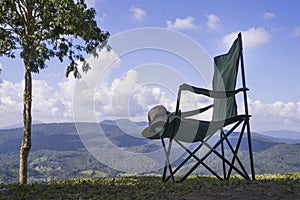 One Empty Camping Chairs and Bucket Hat Standing on the Top of the Mount. Perfect Place for Watching Sunset. Actice Relaxation