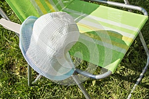 One empty folding garden chair for relaxing stands on the green grass on the lawn on a Sunny summer day, a copy of the space, a