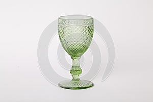 One empty glass of green glass on a stem on a white background