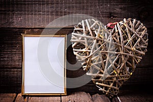 One empty golden frame and decorative heart with fairy light o