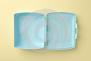 One empty lunch box on beige background, top view