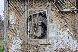 one empty old broken window with a wooden frame on a brown shabby wall