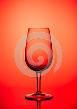 One Empty wine glass isolated on red background