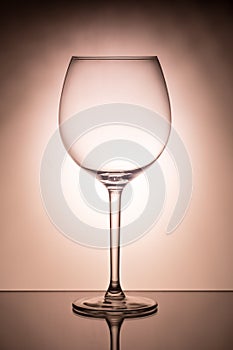 One empty wineglass for red wine on diffusion lit background