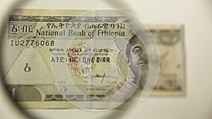 One Ethiopian Birr and magnifying glass.