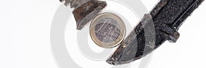 One Euro coin in a black clamp isolated. Panoramic picture