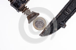 One Euro coin in a black clamp isolated on white