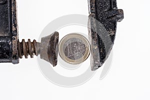 One Euro coin in a black clamp isolated on white