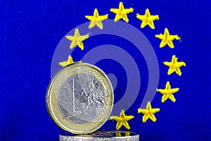 One euro coin and blue Flag of Europe