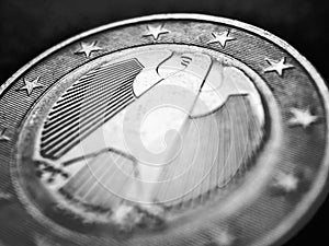 1 one euro coin issued in Germany close up. Dark black and white illustration for European Union currency and German economy news
