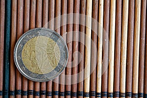 One euro coin lie on wooden bamboo table Denomination is 2 euro - back side