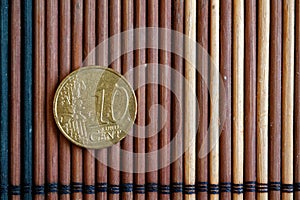 One euro coin lie on wooden bamboo table Denomination is 10 euro cent