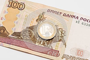 One euro coin lying on a one hundred russian rubles banknote