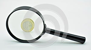 One euro coin observed with a magnifying glass