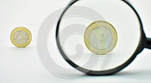 One euro coin observed with a magnifying glass photo