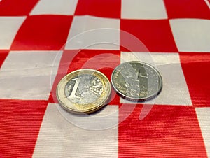 One euro coin placed next to one croatia kuna coin on the white and red squares