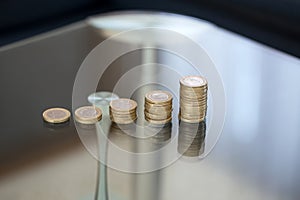 One euro money columns on glass desk