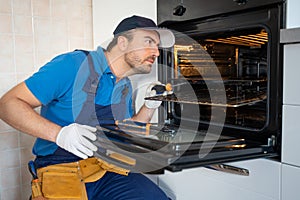 One expert repairman fixing a broken kitchen oven