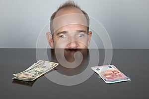 One eye looking at dollar and other at euro banknotes