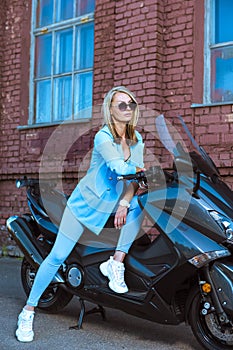 One Female Biker in Blue Suit While Sitting on Shiny New Motorcycle Outdoors