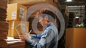 One female worker scan bar codes to check orders at parcels warehouse factory.
