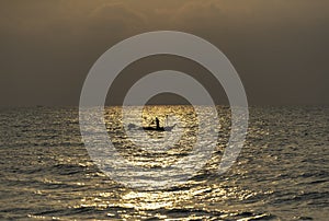 One fisherman on his boat with flash light of Sunrise