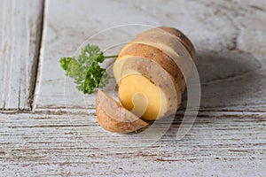 One fresh potato on wood table