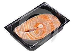 One fresh raw Norwegian salmon steak in a black plastic box