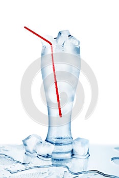 One full transparent glass of cold crystal clear water, red drinking straw, ice cubes condensation drops white background isolated