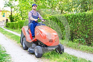 One gardener driving riding lawn mower garden