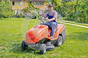 One gardener driving riding lawn mower garden