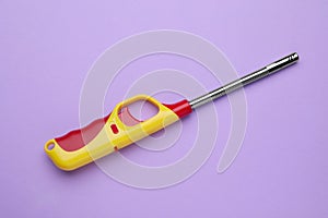 One gas lighter on violet background, top view