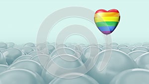 One gay, pride, rainbow heart colour balloon is flying through balloons. White light background. Ideal title text