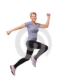 One giant leap to her fitness goal. Studio shot of a beautiful young woman leaping through the air across the frame