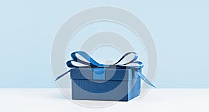 one gift box with a blue bow on light blue monochrome