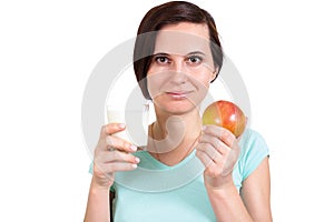 One girl holds apple and a glass of milk