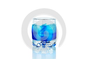 One glass of blue alcohol drink with ice cubes and reflection on white background isolated closeup, blue lagoon cocktail, absinthe