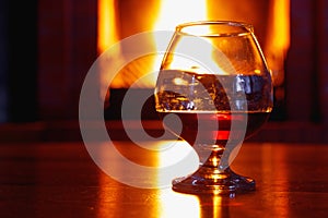 One glass of cognac on background of old brick fireplace