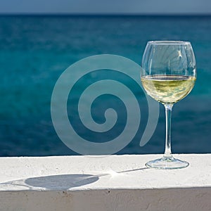 Uno tazza Freddo vino bianco serviamo sul esterno terrazza il mare 