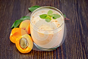 Milkshake apricot in glassful on board