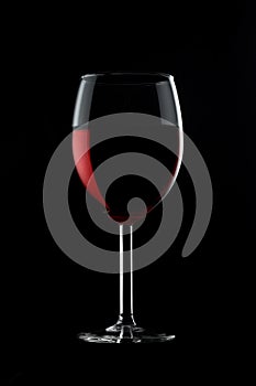 One glassed of red wine isolated on black background