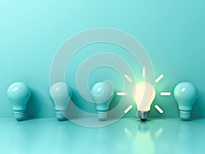 One glowing idea bulb standing out from unlit incandescent bulbs on light green pastel color background