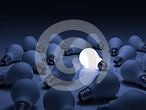 One glowing light bulb standing out from unlit incandescent bulbs with reflection on blue background