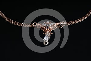 gold chain with a suspension bracket on a black background